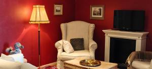 a living room with a chair and a television at Wiisalan Kartano in Savonlinna