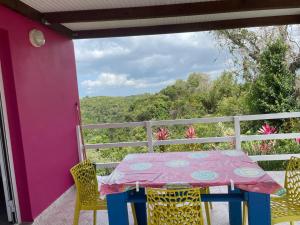 a table and chairs on a porch with a view at colibris Location SAINTE-ANNE in Sainte-Anne