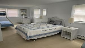ein Schlafzimmer mit einem großen Bett und zwei Fenstern in der Unterkunft Beach Badges, Wifi, Private Yard, Washer Dryer, Roomy Cape Located Bayside In Long Beach Island New Jersey in Ship Bottom