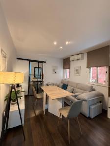 een woonkamer met een bank en een tafel bij Apartamento Azonaicas in Córdoba