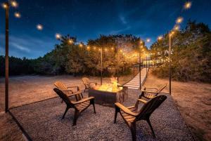 a group of chairs around a fire pit at night at Austin Spacious Haven - Pool Jacuzzi Firepit in Bee Cave