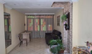 a living room with a couch and a table at Aconchego da Marci Grande quarto confortável in Belém