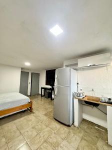 a kitchen with a refrigerator and a bed in it at Apartamento com varanda 201 in Brasilia