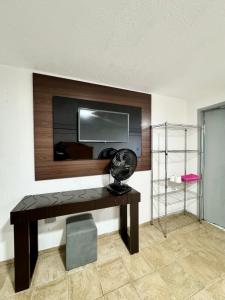 a room with a desk with a television on a wall at Apartamento com varanda 201 in Brasilia