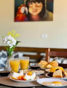 a table with plates of eggs and bread and glasses of orange juice at Pousada Zoom Jericoacoara in Jericoacoara