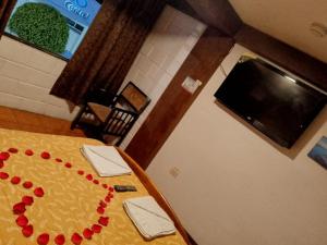 Una mesa con decoraciones rojas en una habitación. en Hostal GRIMALDI, en Baños 15 fotos más