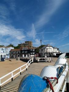 un bateau assis sur un quai avec une promenade dans l'établissement Broadstairs House Boutique B&B By The Sea, à Broadstairs