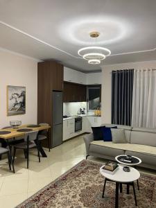 een woonkamer met een bank en een tafel bij Deluxe Apartment in Fier