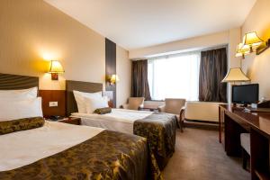クルジュ・ナポカにあるGrand Hotel Napocaのベッド2台とテレビが備わるホテルルームです。