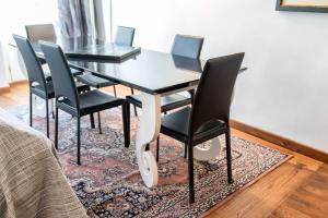 un tavolo da pranzo nero con sedie nere su un tappeto di Lamihouse ad Aosta