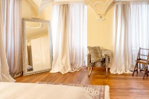 una camera da letto con specchio e sedia davanti ofermottermottermott di Lamihouse ad Aosta Altre 38 foto