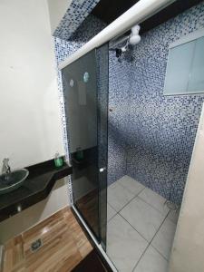 a bathroom with a shower and a sink at Recanto Remanso in Queimados