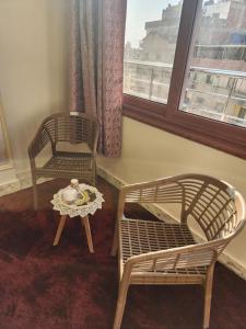 two chairs and a table in a room with a window at Hotel rooms in front of Mansoura University in Mansoura
