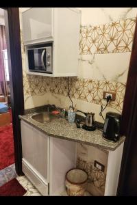 a small kitchen with a sink and a microwave at Hotel rooms in front of Mansoura University in Mansoura +69 photos