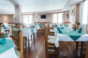 a restaurant with tables and chairs with green and white tablecloths at Hotel Alameda in Zarautz