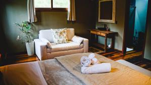 a bedroom with a bed and a chair and a couch at Parque Nacional EcoResort in Urubici
