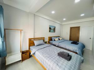 een slaapkamer met twee bedden en een spiegel bij Sun sun house in Chiang Mai