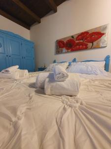 a white bed with towels on top of it at Palmas Anna's rooms Is Procilis in Palmas Arborea