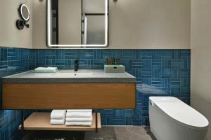 un bagno con lavandino, water e specchio di Four Points by Sheraton Hengyang Zhengxiang ad Hengyang