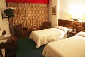 um quarto de hotel com duas camas e uma janela em Monclús em Palencia