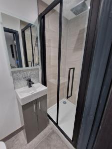 une salle de bains avec douche, lavabo et miroir dans l'établissement Stylish 3 bed 3 ensuites house with parking & garden, à Reading 11 autres photos