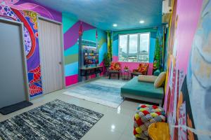 a colorful living room with a couch and a window at The Arts Smart Home Terengganu in Kuala Terengganu