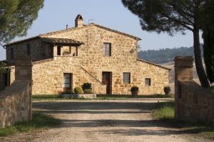 an old stone house with a tree in front of it at Agriturismo Il Casalino in Pienza