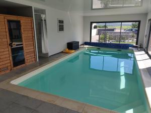 a swimming pool with blue water in a house at Choupinerie Normande in Criquebeuf-sur-Seine