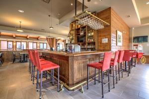 a bar with red chairs at a restaurant at Le Grand R in Saint-Donat-de-Montcalm