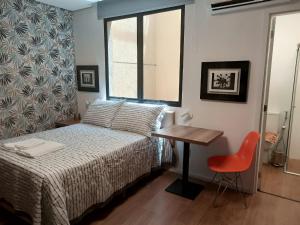 ベロオリゾンテにあるGuaja 745のベッドと机と窓のある寝室
