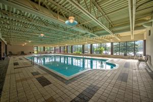 a large pool in a large building with a large window at Le Grand R in Saint-Donat-de-Montcalm