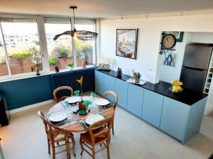 Una cocina con una mesa y armarios azules. en 360 degrés sur la rochelle chambre d hôte, en La Rochelle