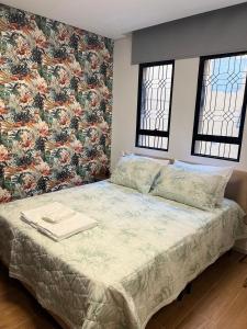 ベロオリゾンテにあるGuaja 745の花柄の壁紙が貼られたベッドのある寝室