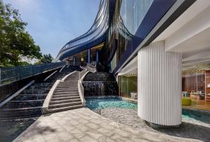 万隆Hotel Indigo Bandung Dago Pakar by IHG的一座带楼梯的游泳池,位于大楼旁