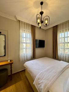 a bedroom with a large white bed and windows at Adria Inn in Antalya