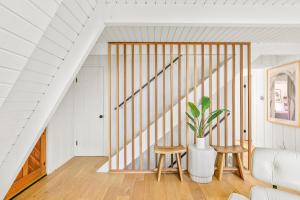 a staircase in a house with two chairs and a potted plant at Luxury A-Frame Retreat in Lake Arrowhead +37 photos