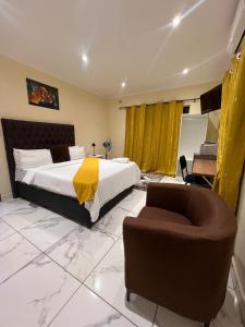 a bedroom with a bed and a chair and a desk at Kitty Guest House in Bellville