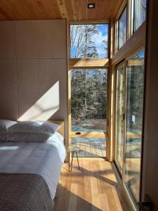 a bedroom with a bed and a large window at Brooklyn Shore Lodge in Liverpool