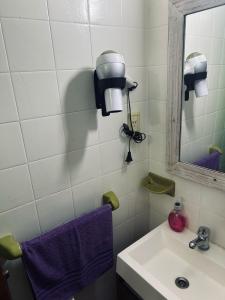 a bathroom with a sink and a mirror and purple towel at Departamento ESPAÑA in Paraná