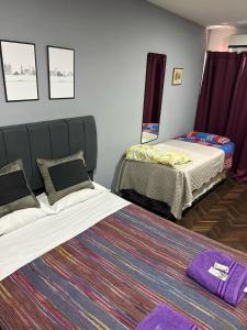 a bedroom with two beds and a rug at Departamento ESPAÑA in Paraná