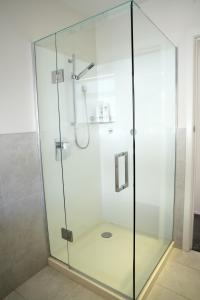 a shower with a glass door in a bathroom at Sunny Villa Guest House in Auckland