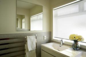 a bathroom with a sink and a vase of flowers at Sunny Villa Guest House in Auckland +25 photos