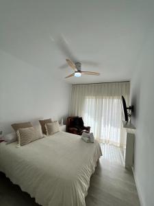 a white bedroom with a bed and a ceiling fan at Fuengirola, Doña Sofia amazing sea view in Fuengirola