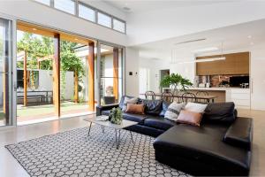 a living room with a black couch and a table at Norwood Haven- Pool - Pet Friendly & Free WiFi in Norwood