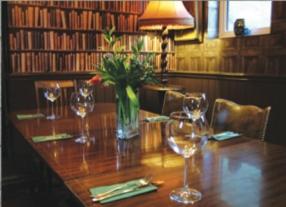 uma mesa de madeira com copos de vinho e um vaso com flores em Robin Hood Inn em Wall Houses