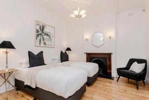 1 Schlafzimmer mit 2 Betten, einem Stuhl und einem Kamin in der Unterkunft Oasis - Luxe living, with pool - walk to cafes in Rose Park + 43 Fotos