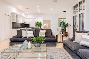 ein Wohnzimmer mit zwei Sofas und einem Tisch in der Unterkunft Oasis - Luxe living, with pool - walk to cafes in Rose Park