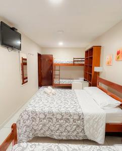 a bedroom with a bed and two bunk beds at Yes Hotel Pousada in Abraão