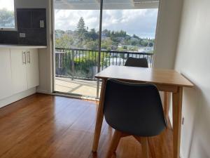 a kitchen with a table and chairs and a large window at Living Oasis Home in Auckland +9 photos
