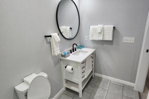 a white bathroom with a sink and a mirror at Peaceful Midtown Apartment with Gym and Parking in Tulsa +13 photos